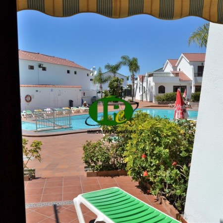 Bungalow de un dormitorio, terraza abierta de azulejos con vistas a la piscina comunitaria
